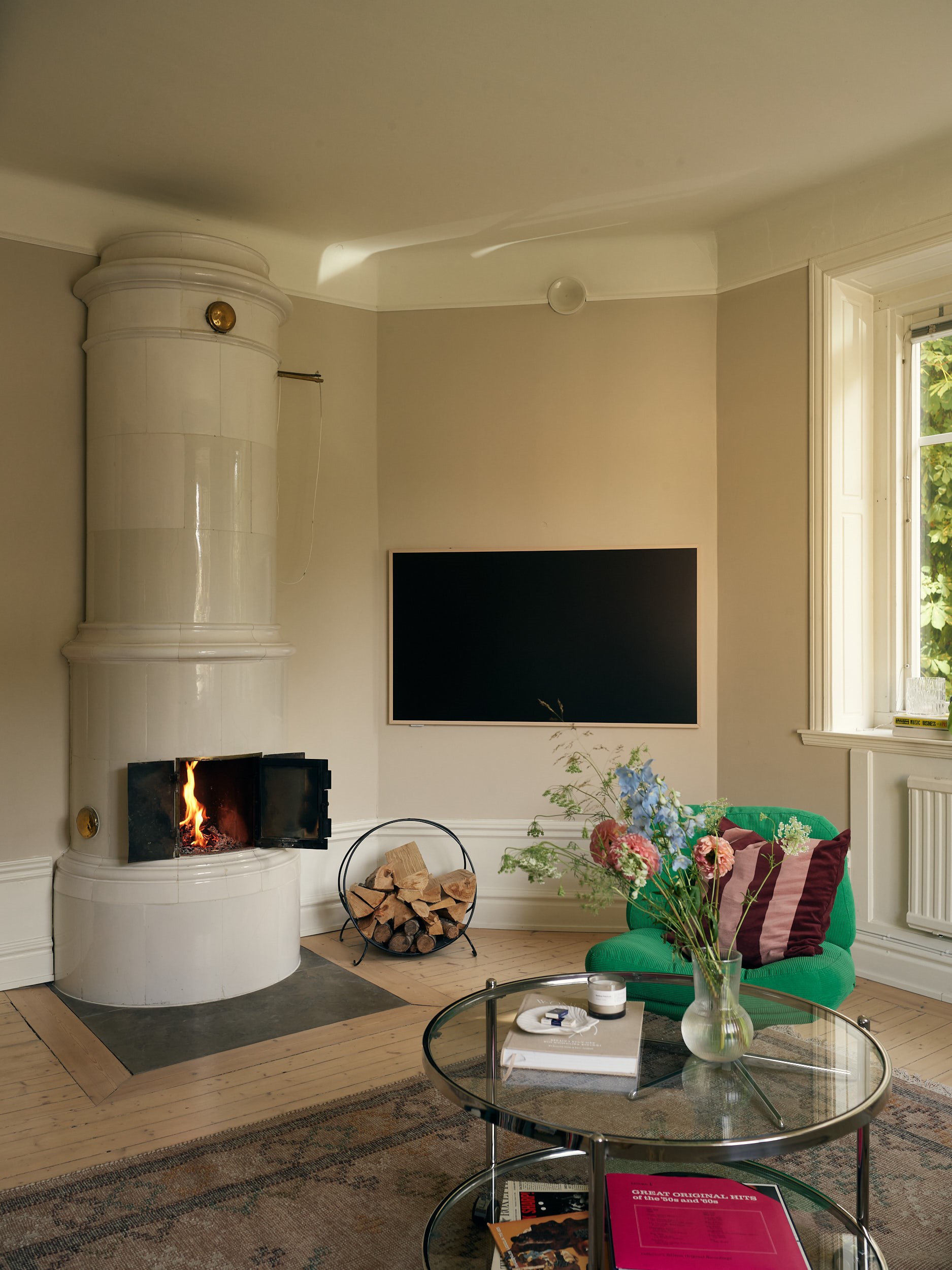 historic stove in living room with green IKEA vintage armchair 58sqm apartment Scandinavian decor