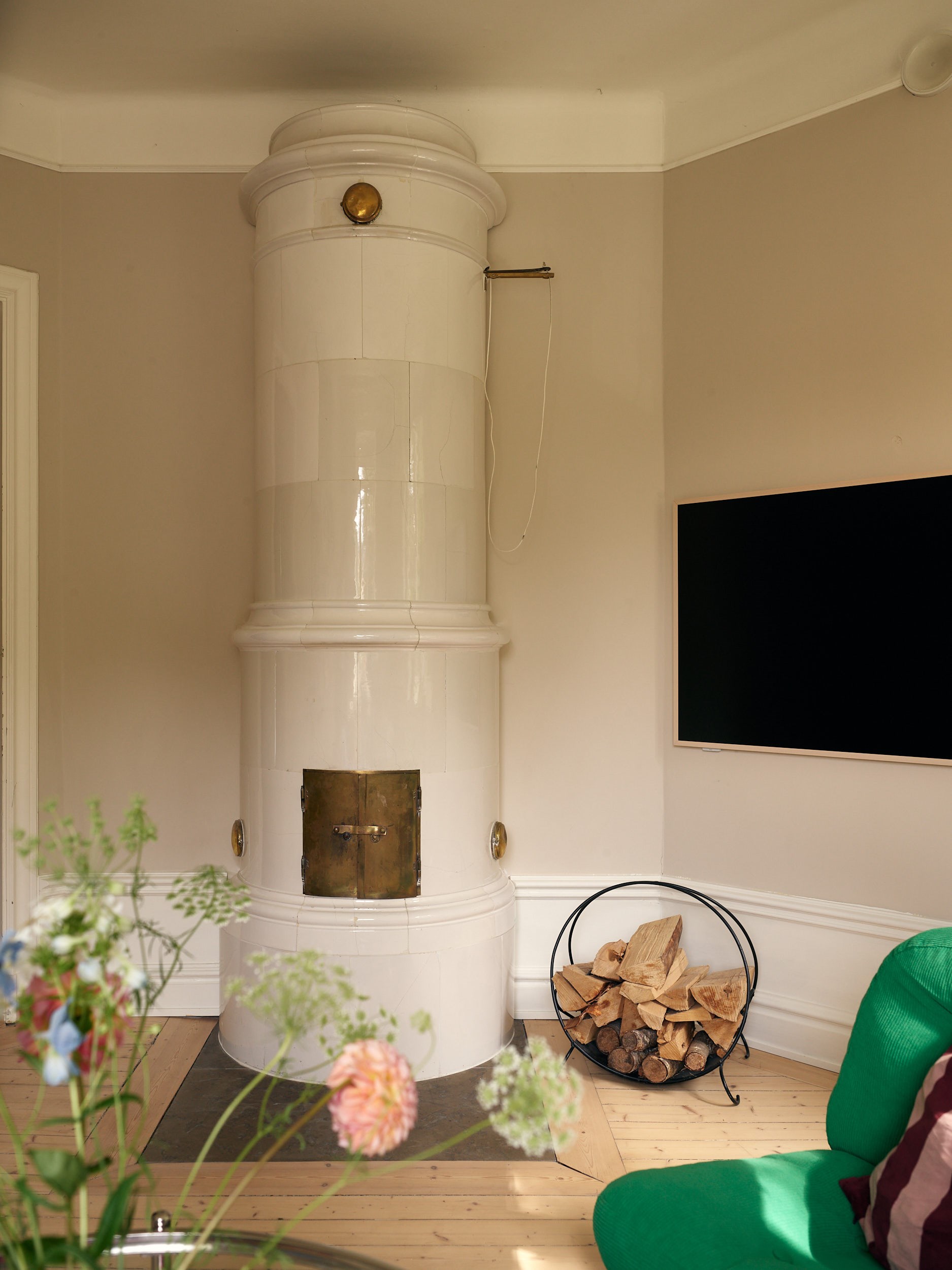 living room with green IKEA vintage armchair and historic stove 58sqm apartment Scandinavian decor