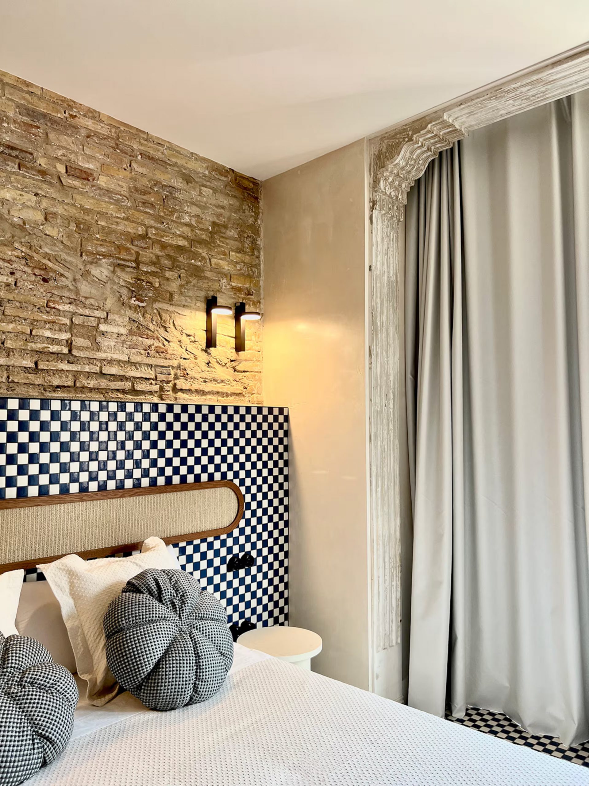 chambre avec carrelage à damier et mur de briques ancienne décoration contemporaine maison de pêcheur rénovée à Valencia El Rincón de María Vicenta