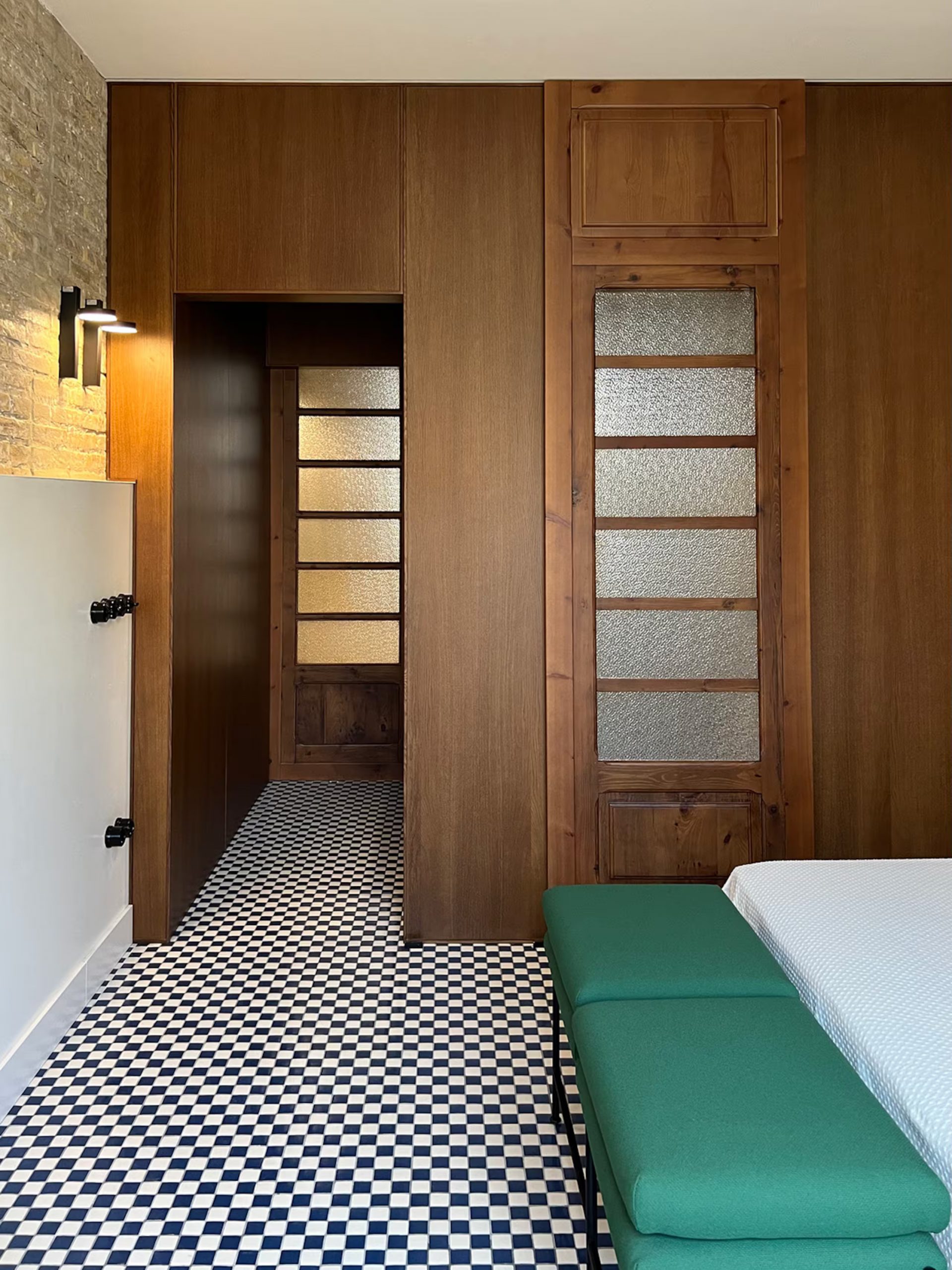 chambre avec carrelage à damier et mur de briques ancienne décoration contemporaine maison de pêcheur rénovée à Valencia El Rincón de María Vicenta