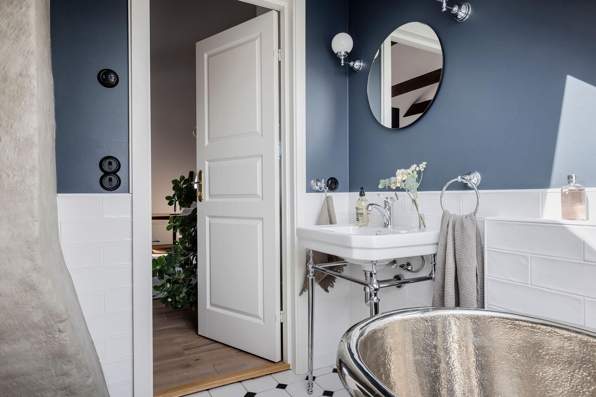 salle de bain murs bleus avec baignoire cuivre rétro