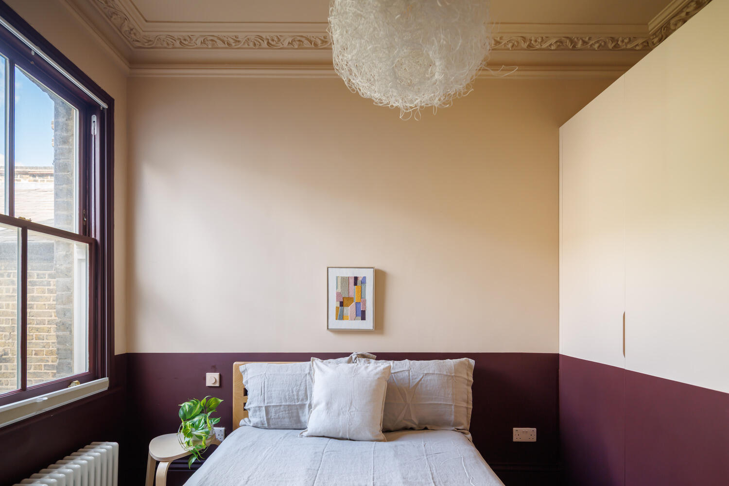 chambre beige et bordeaux avec fenêtre à guillotine dans appartement dans maison victorienne à Londres décoration colorée style color blocking chambre beige et bordeaux avec fenêtre à guillotine dans appartement dans maison victorienne à Londres décoration colorée style color blocking