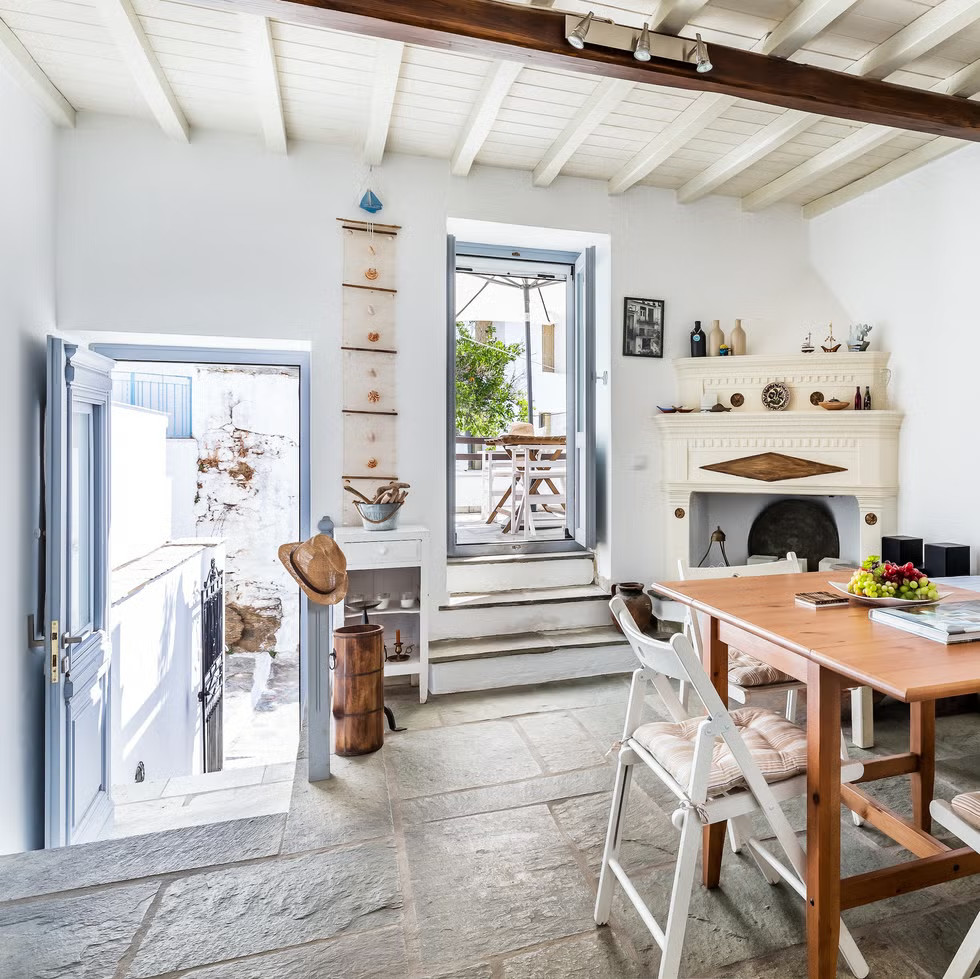 salle à manger avec cheminée ancienne et poutres décoration bleue et blanche maison Grèce salle à manger avec cheminée ancienne et poutres décoration bleue et blanche maison Grèce