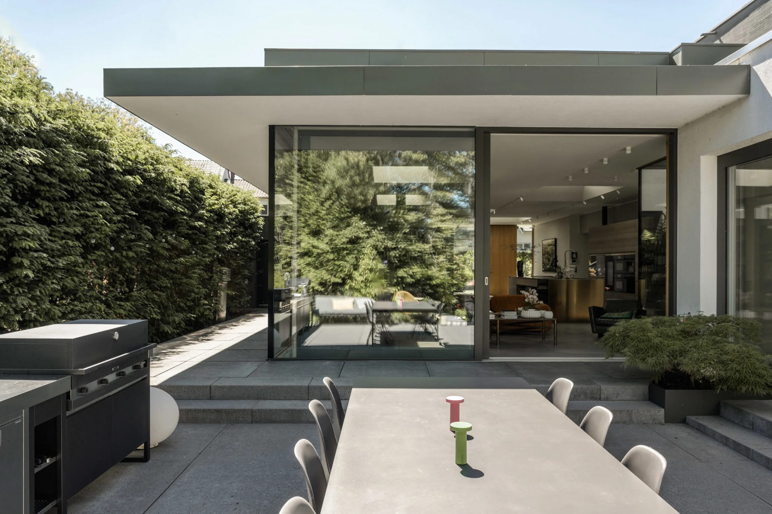 terrasse carrelage gris avec salle à manger extérieur et cuisine d'été maison d'architecte