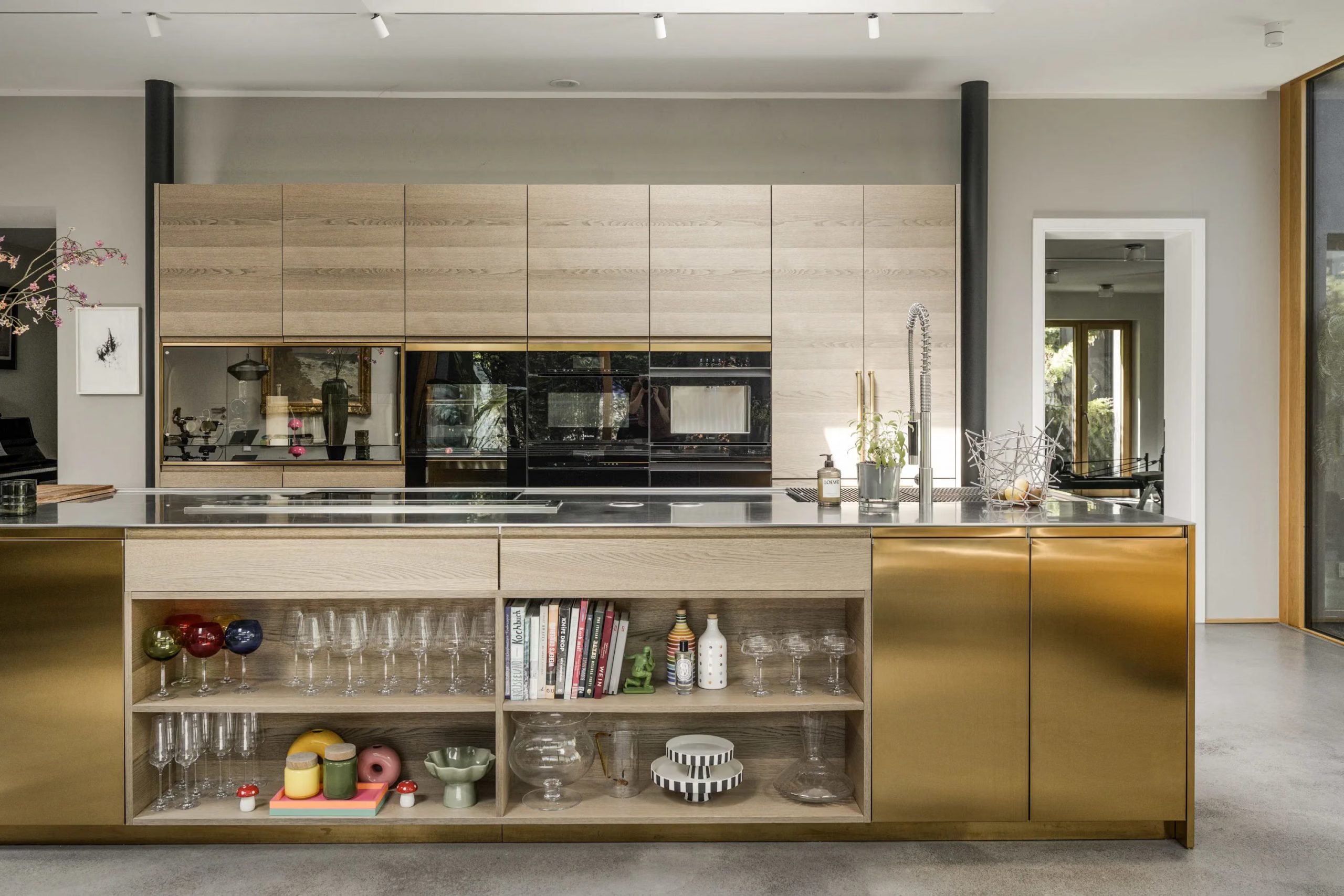 cuisine ouverte laiton et bois décoration design et contemporaine sol béton ciré grandes baies vitrées maison d'architecte