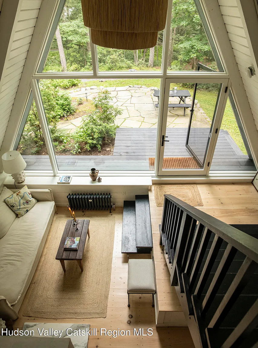 salon mansardé avec escalier décoration naturelle neutre maison A-Frame des années 1970