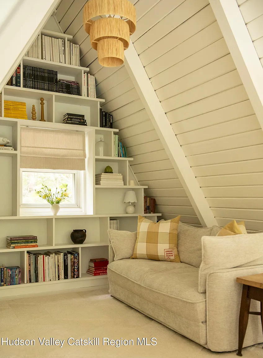 salon mansardé avec bibliothèque décoration naturelle neutre maison A-Frame des années 1970
