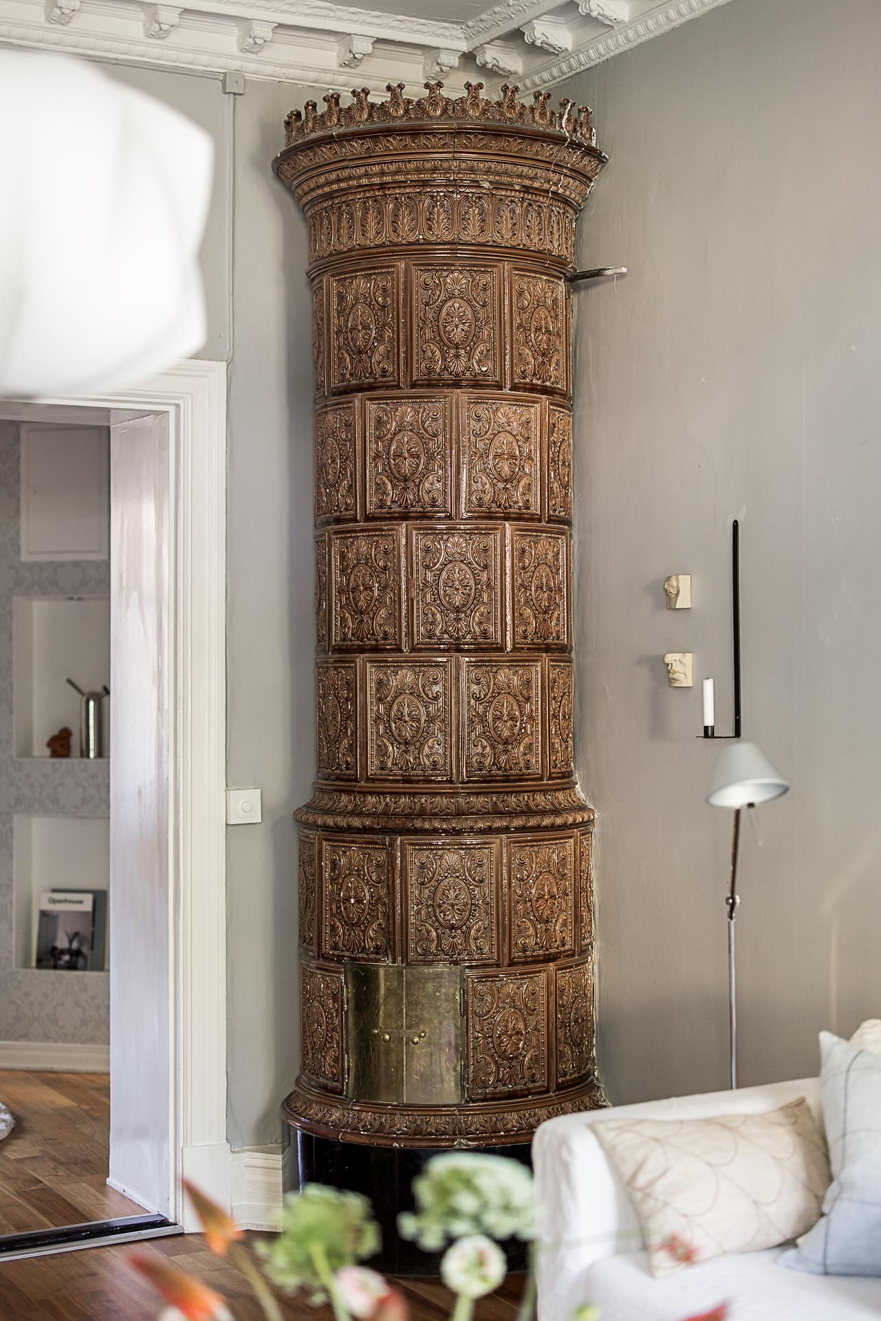 salon avec poêle en faïence suédois kakelugn et moulures murs gris décoration scandinave