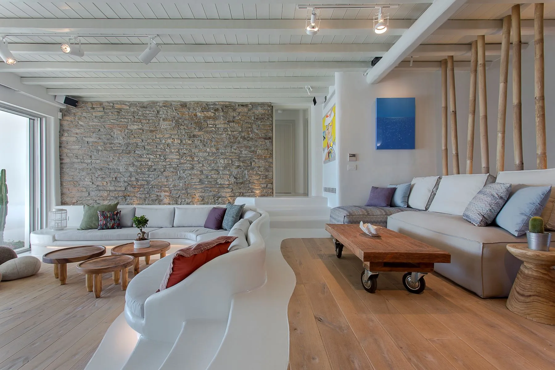 salon vue mer décoration contemporaine mur de pierres maison design à Mykonos avec piscine