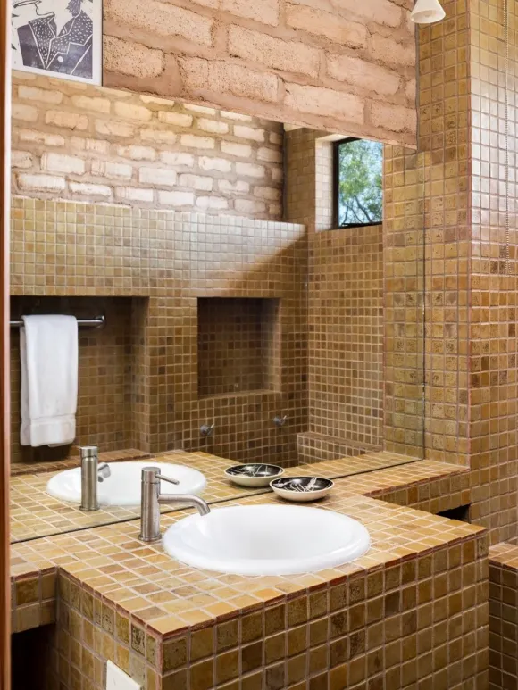 salle de bain petit carrelage marron murs briques maison Marfa