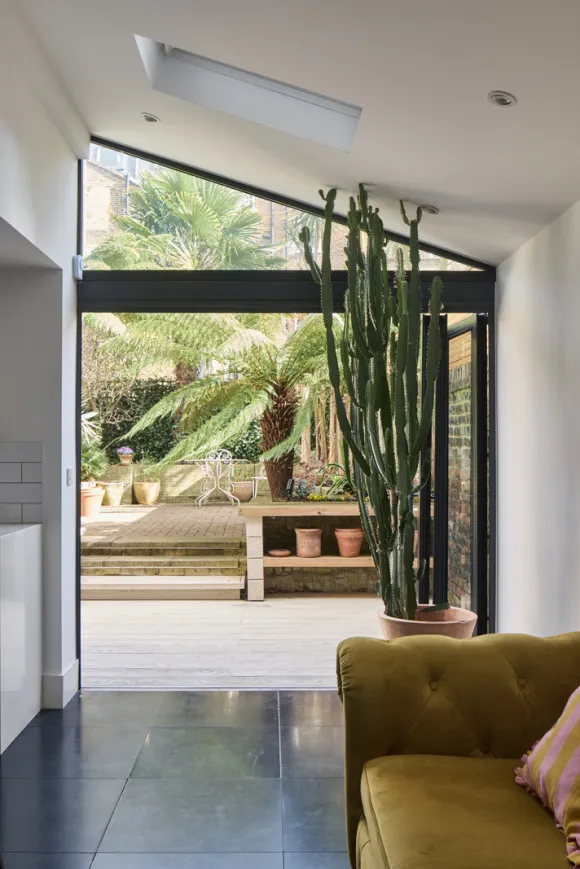 cuisine noire sur jardin avec canapé chesterfied velours jaune