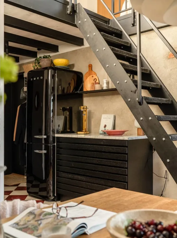 cuisine noire design avec sol à damier rouge et blanc et escalier acier noir dans appartement en duplex décoration scandinave