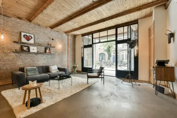 salon sol béton ciré loft 105m2 Amsterdam mur briques anciennes